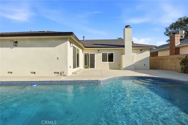a backyard of a house with table and chairs