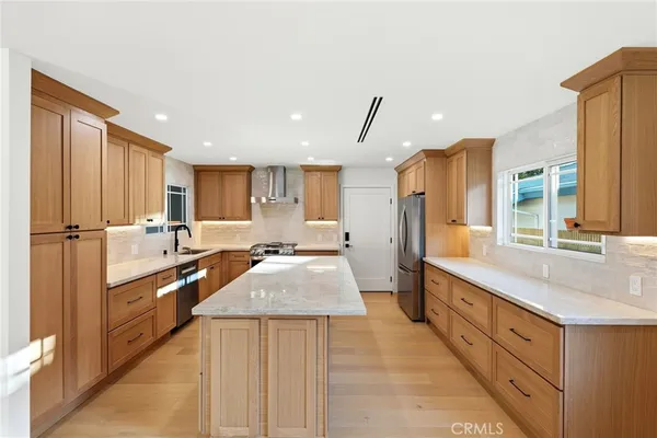a large kitchen with stainless steel appliances kitchen island granite countertop a sink and cabinets