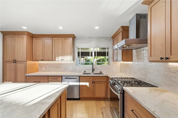 a kitchen with stainless steel appliances granite countertop a sink stove and refrigerator