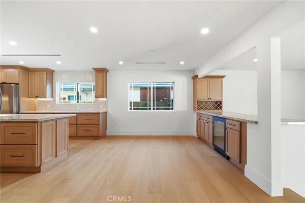 a open kitchen with kitchen island wooden floors and white appliances