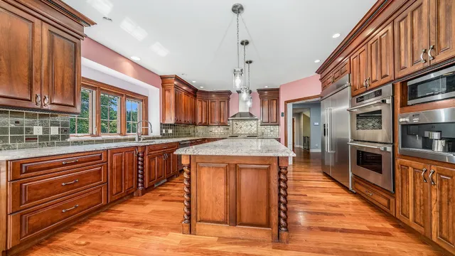 a kitchen with stainless steel appliances granite countertop a refrigerator a stove and a sink