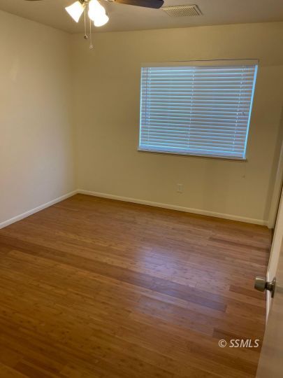 201 Kimberly Lane Ridgecrest, CA 93555 - Photo 5 of 10 a view of an empty room with wooden floor and a window