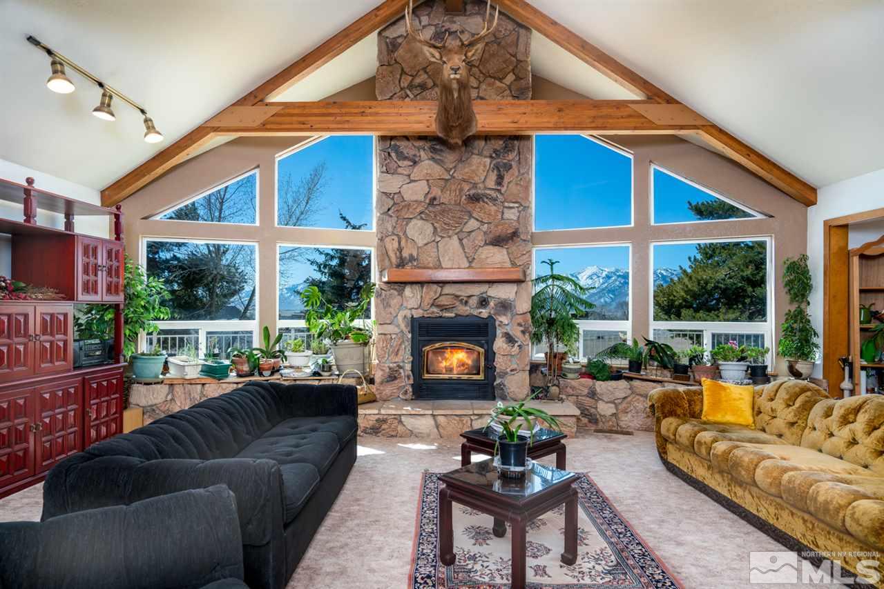 a living room with fireplace furniture and a large window