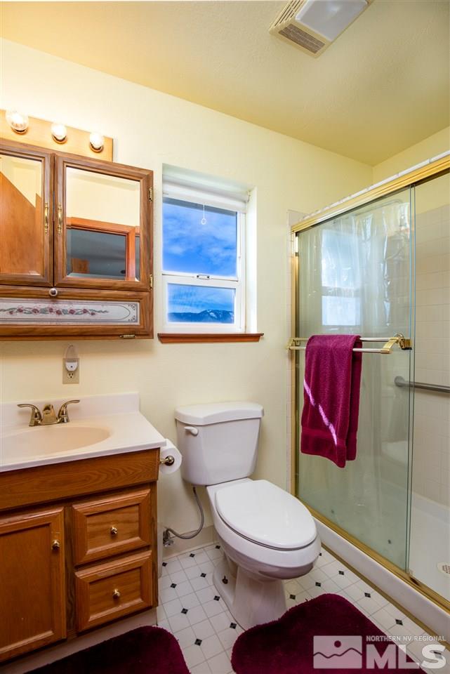 1719 Sunrise Pass Road Minden, NV 89423 - Photo 18 of 39 a bathroom with a toilet a sink and mirror