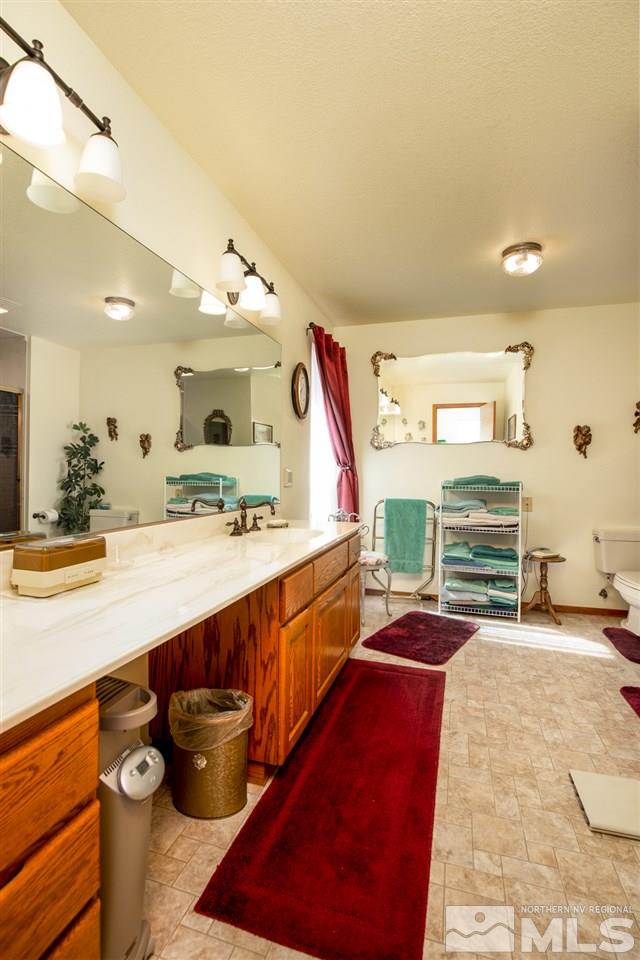 1719 Sunrise Pass Road Minden, NV 89423 - Photo 24 of 39 a bathroom with a sink a mirror and a bath tub