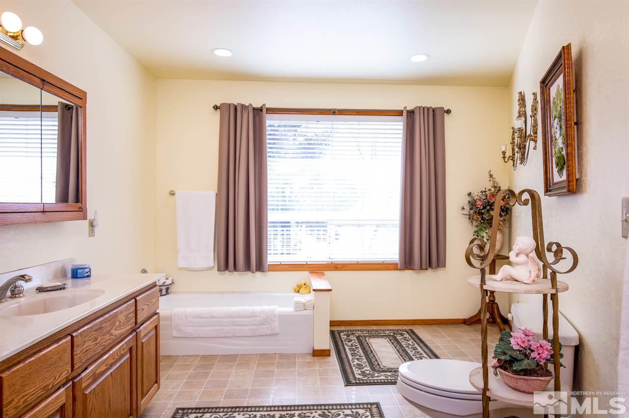 1719 Sunrise Pass Road Minden, NV 89423 - Photo 26 of 39 a bathroom with a tub sink toilet and mirror