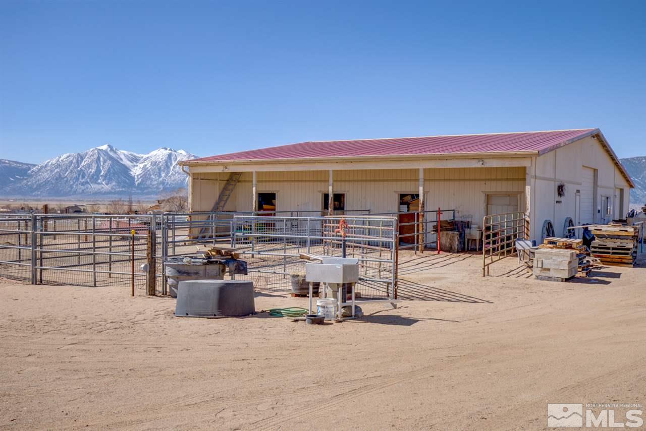 1719 Sunrise Pass Road Minden, NV 89423 - Photo 33 of 39 a view of a patio with dining table and chairs under an umbrella next to a yard