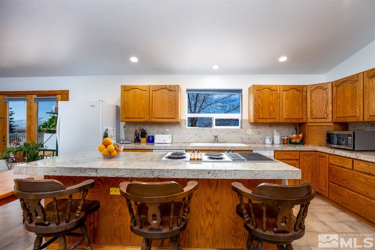 1719 Sunrise Pass Road Minden, NV 89423 - Photo 8 of 39 a kitchen with stainless steel appliances granite countertop a stove a sink dishwasher and cabinets with wooden floor