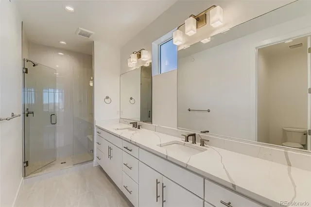 a bathroom with a double vanity sink mirror and shower