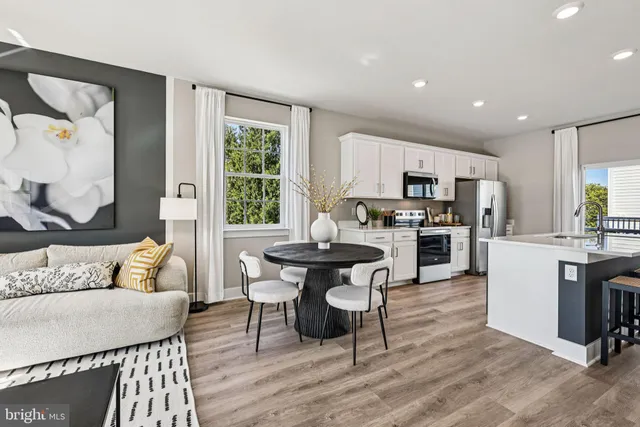 a kitchen with microwave a refrigerator and chairs