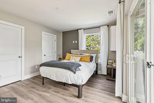 a bed sitting in a spacious bedroom next to a window