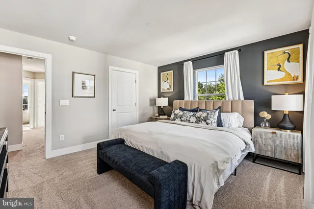 a spacious bedroom with a bed a couch and a window