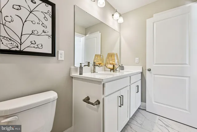 a bathroom with a sink mirror vanity and toilet