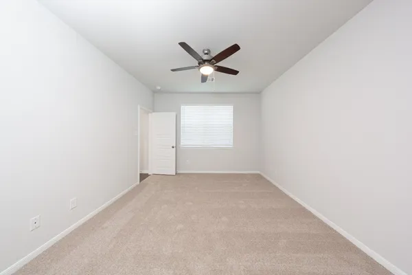 an empty room with a window and a fan