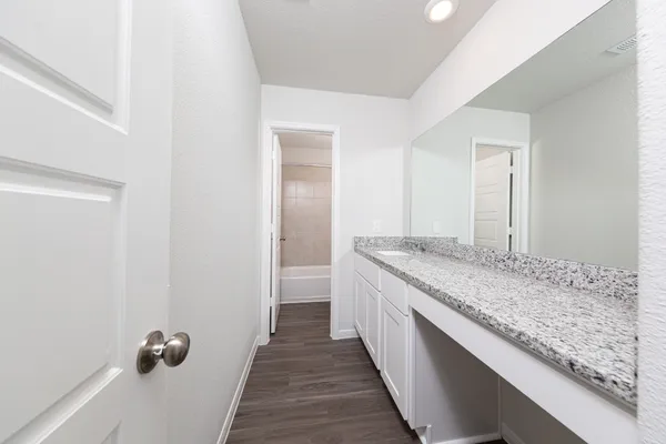 a bathroom with a granite countertop sink and a mirror
