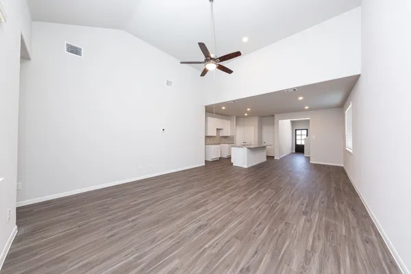 a view of a room with wooden floor and a ceiling fan