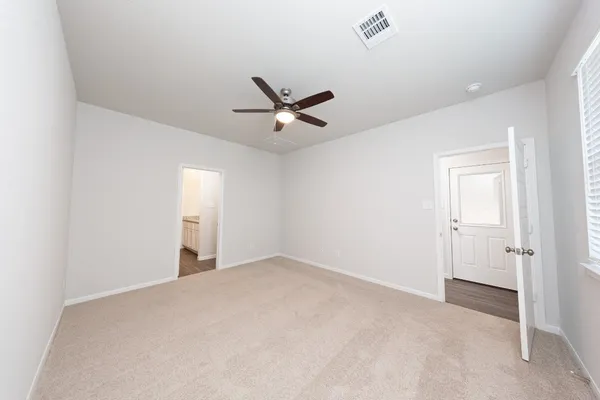 an empty room with closet and ceiling fan
