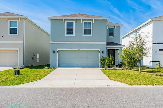 a front view of a house with a yard and garage