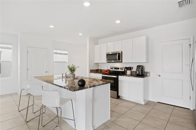 a kitchen with white cabinets and appliances