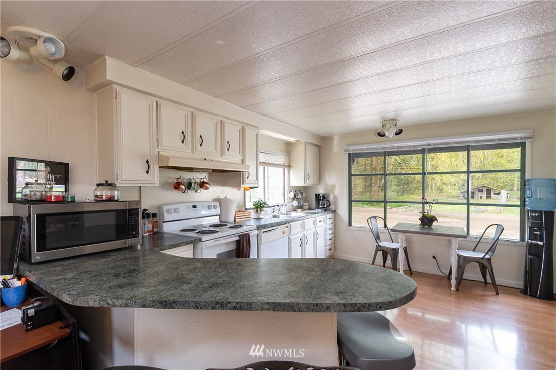2073 East Pole Road Everson, WA 98247 - Photo 11 of 18 a kitchen with counter top space cabinets dining table and stainless steel appliances