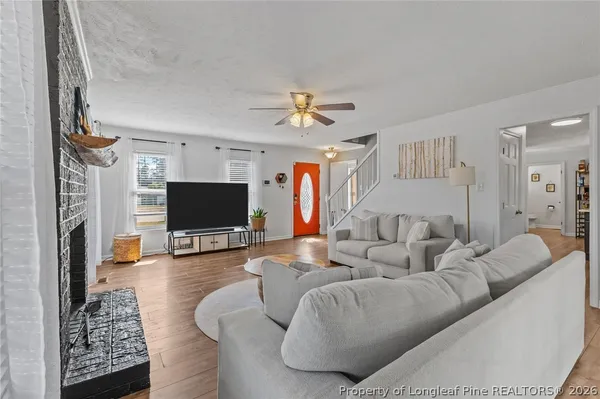 a living room with furniture a flat screen tv and a fireplace