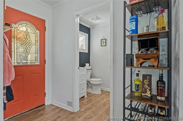 a view of a hallway with wooden floor and a potted plant