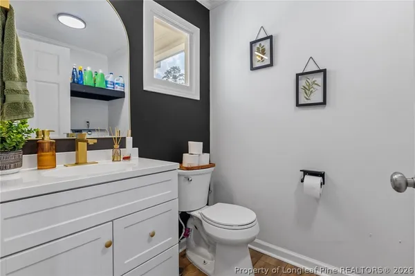 a bathroom with a sink mirror vanity and toilet