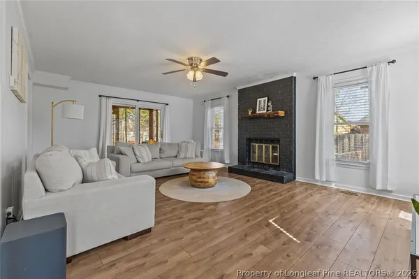 a living room with fireplace furniture and a wooden floor