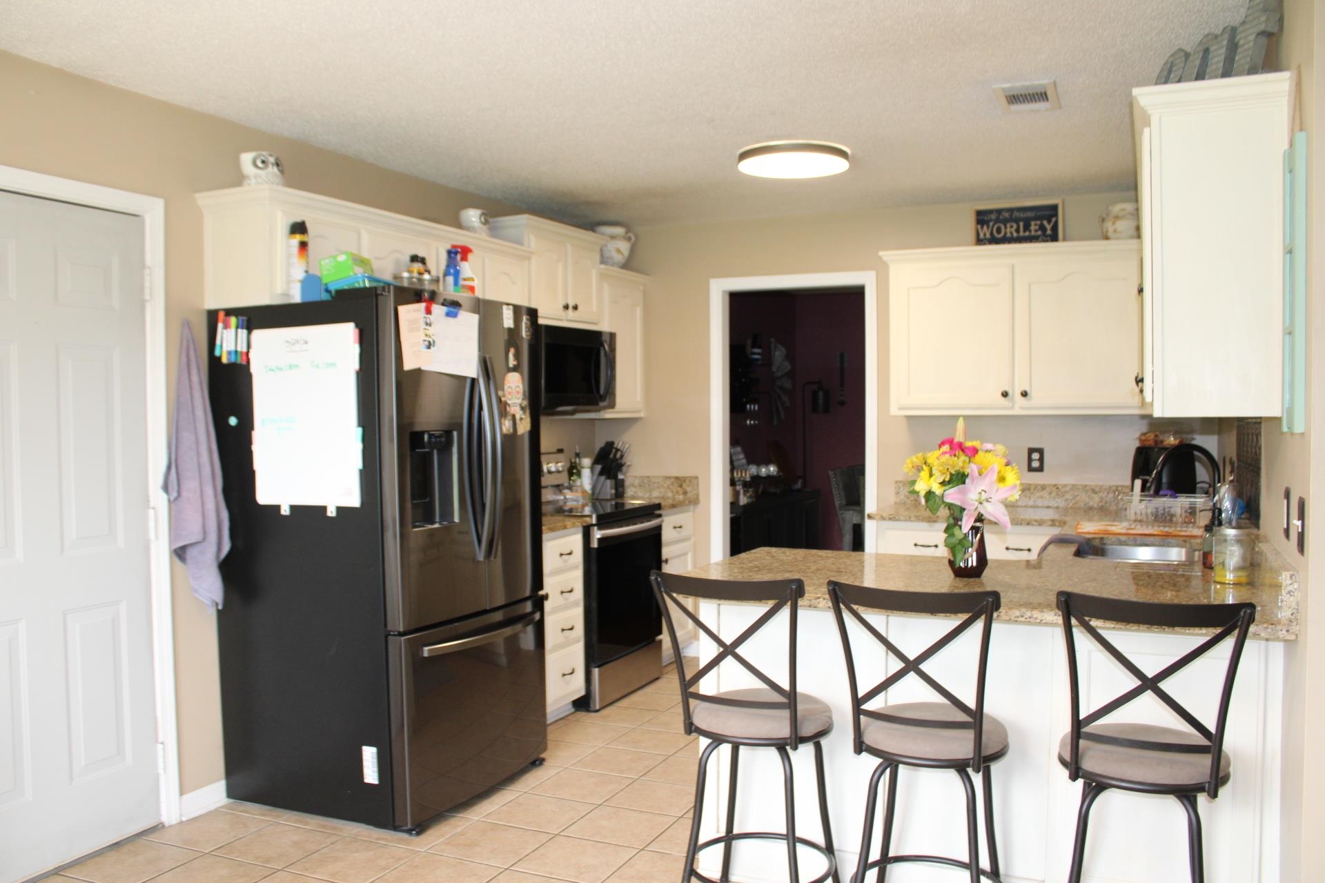 64 Buck Stand Road Atoka, TN 38004 - Photo 15 of 39 a kitchen with stainless steel appliances kitchen island granite countertop a refrigerator and microwave