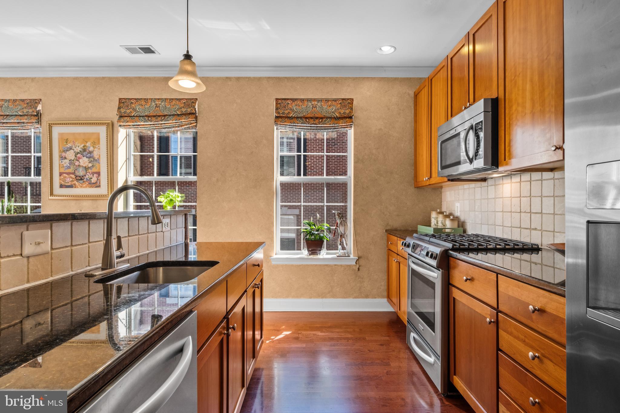 600 Commodore Court, Unit 2631 Philadelphia, PA 19146 - Photo 13 of 45 a kitchen with stainless steel appliances granite countertop a stove a sink and a granite counter tops with wooden floors