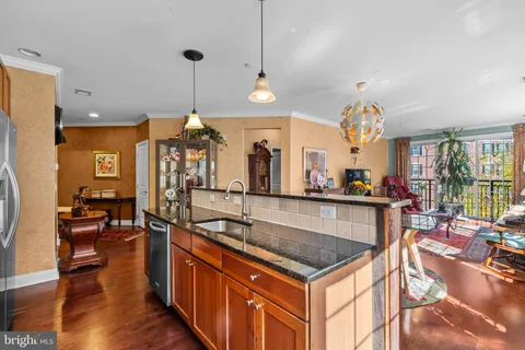 a kitchen with stainless steel appliances granite countertop a sink a stove and a wooden floors