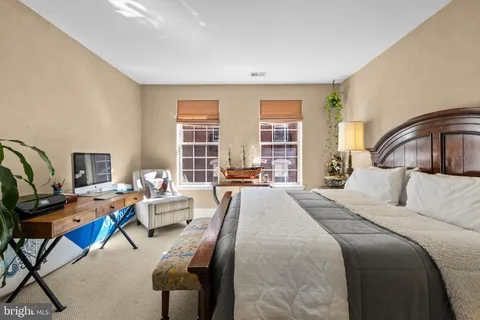 a bedroom with a bed a couch and a window