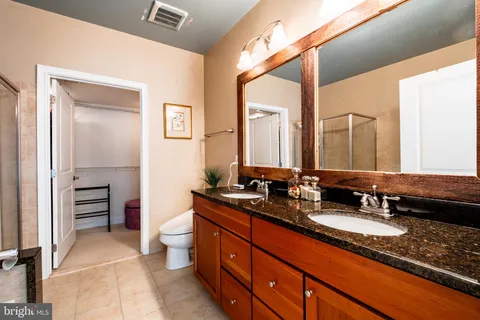 a bathroom with a double vanity sink toilet and a mirror