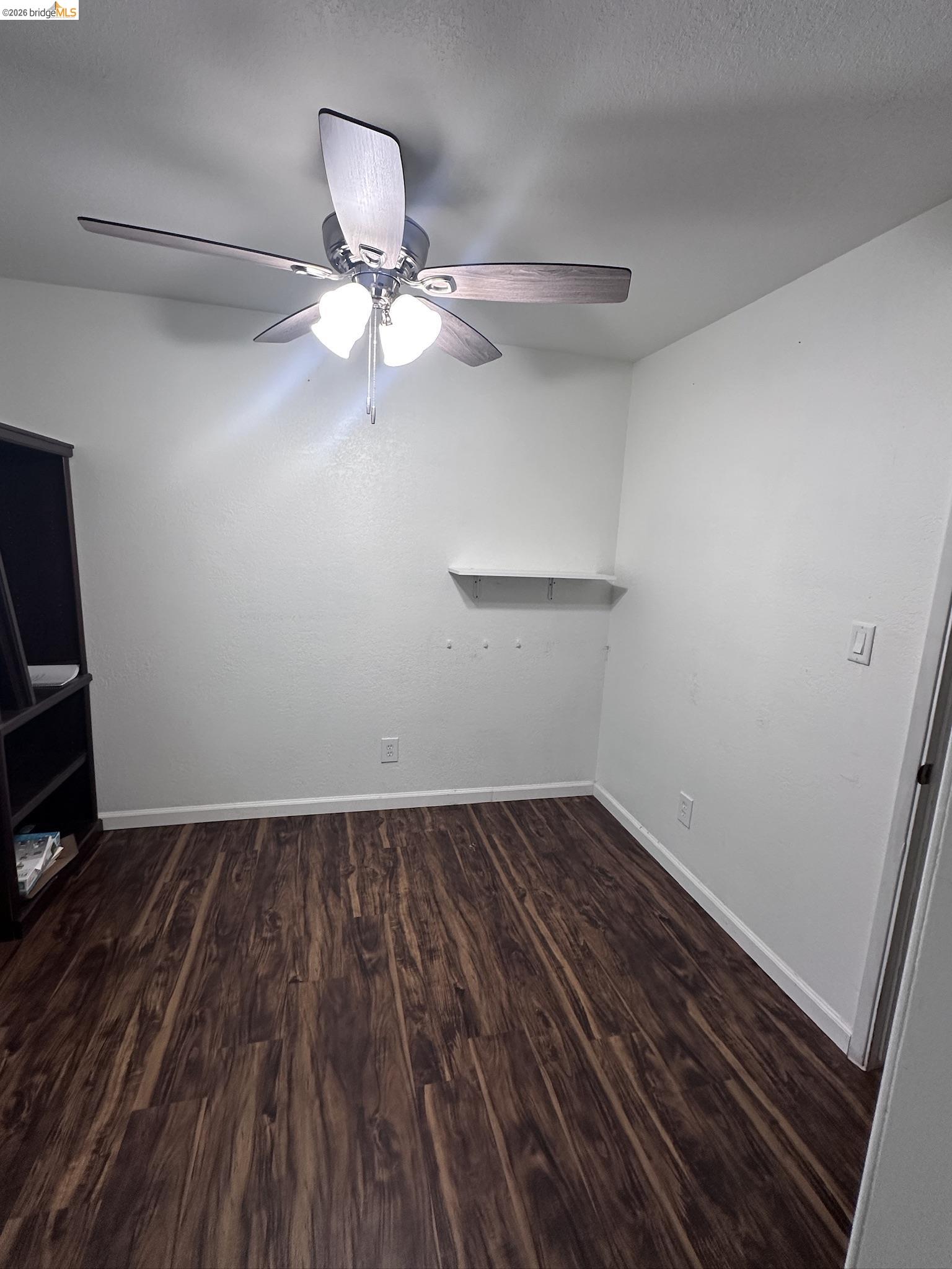 10458 Southworth Road Valley Springs, CA 95252 - Photo 18 of 24 Empty room featuring dark wood-style flooring and ceiling fan