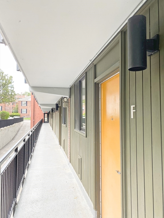 345 Harvard Street, Unit U1F Cambridge, MA 02138 - Photo 15 of 19 a view of a hallway with wooden floor and staircase