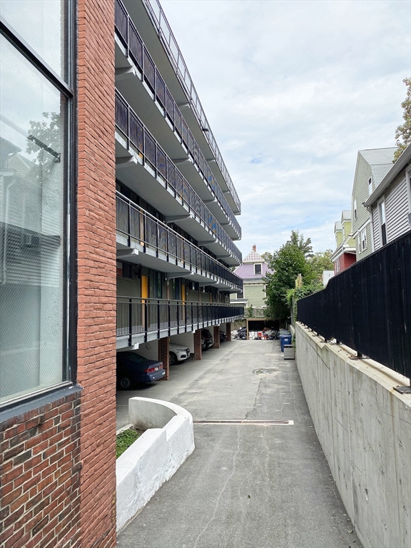 345 Harvard Street, Unit U1F Cambridge, MA 02138 - Photo 16 of 19 a view of a house with a yard