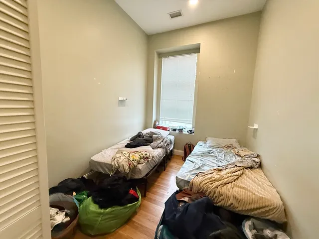 a bedroom with two bed and a window