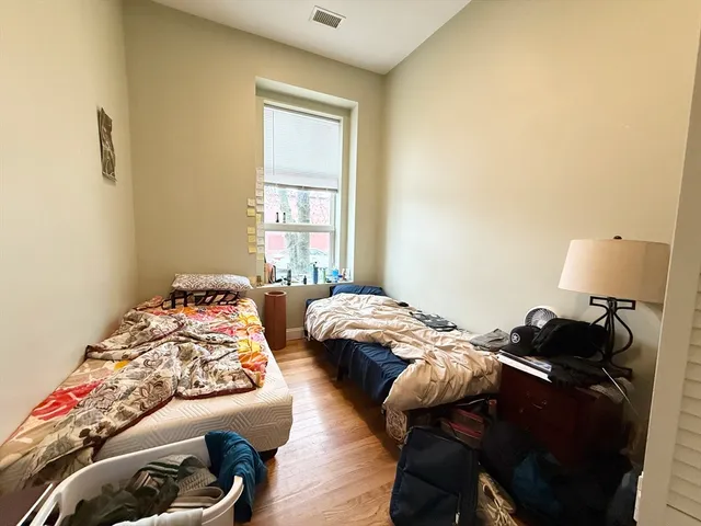 a bedroom with two bed and a window