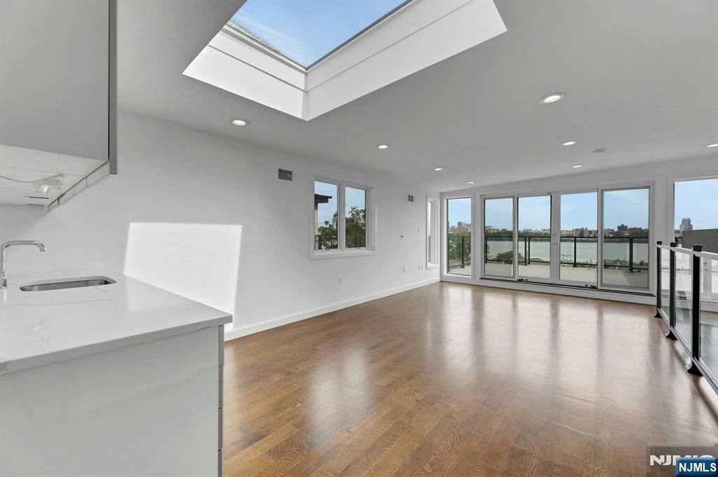 714 Undercliff Avenue, Unit 714 Edgewater, NJ 07020 - Photo 40 of 45 a view of an empty room with wooden floor and a floor to ceiling window