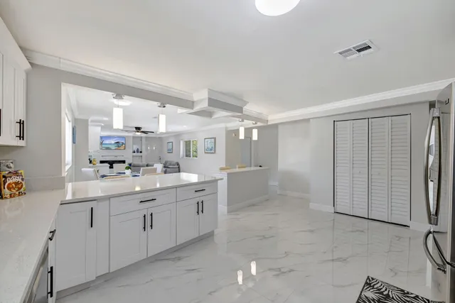 a kitchen with a refrigerator sink and white cabinets