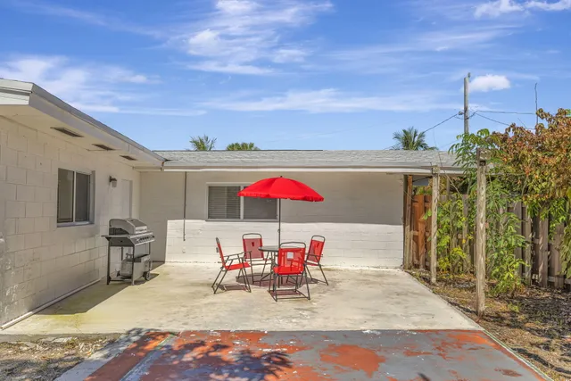 an outdoor sitting area with chairs and umbrella