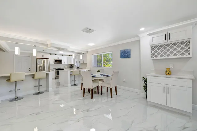 a large white kitchen with a lot of counter space and wooden floor