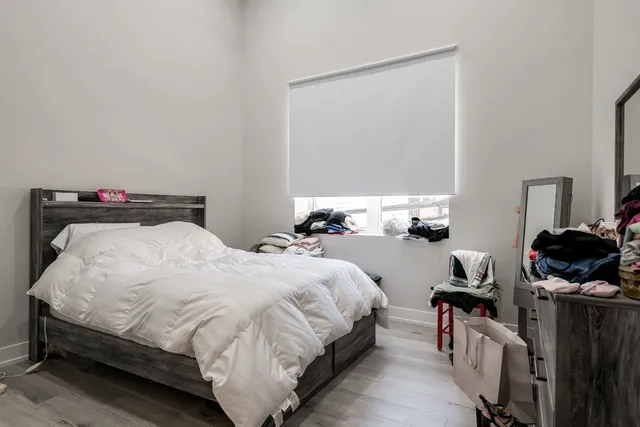 a bedroom with a bed and wooden floor