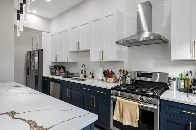 a kitchen with stainless steel appliances a stove a refrigerator and cabinets