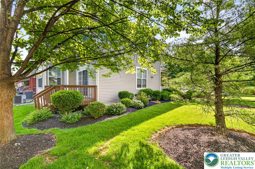 4345 Creek Road Allentown, PA 18104 - Photo 30 of 33 A verdant lawn wraps around a charming home, featuring a welcoming deck with lush landscaping.