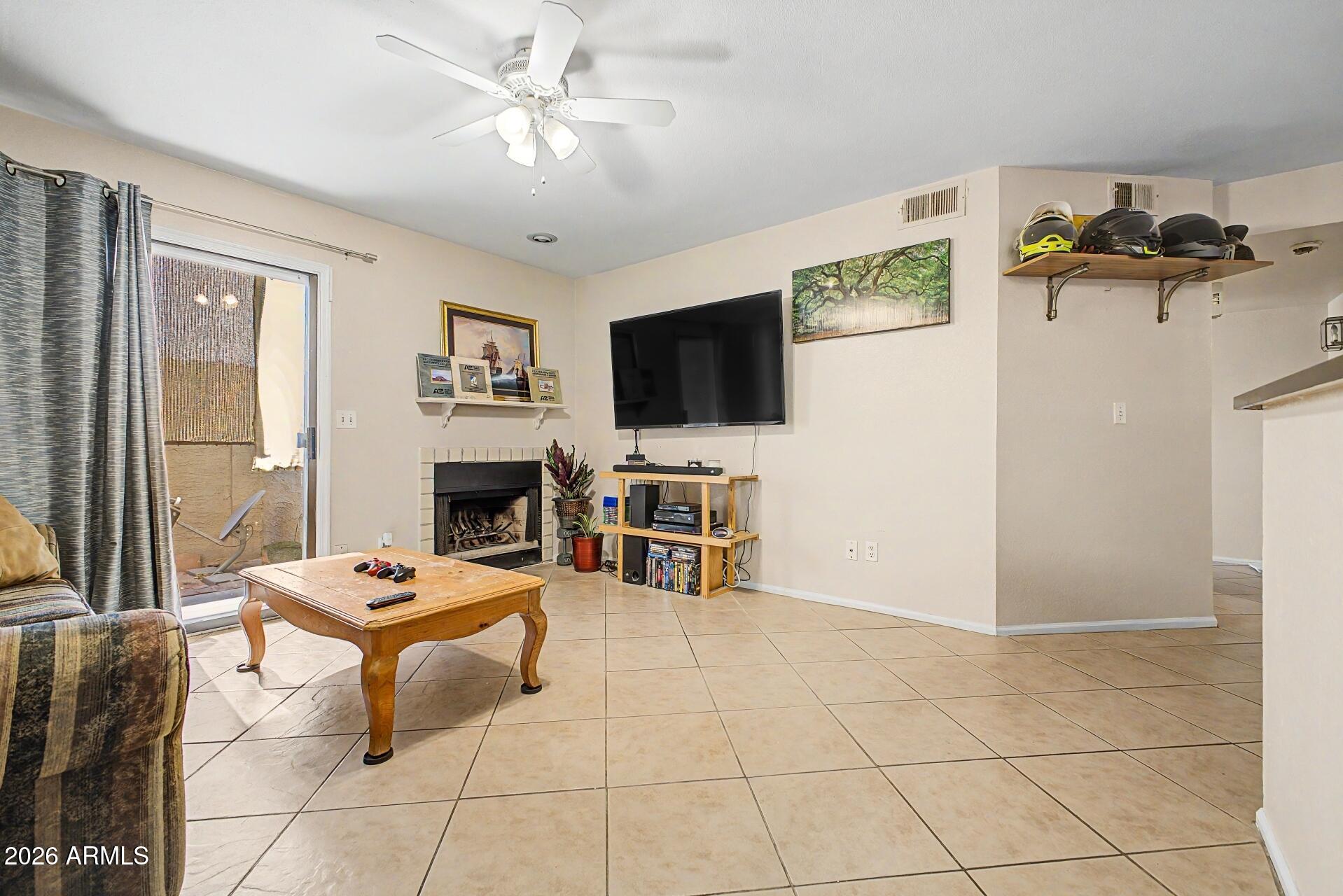 533 West Guadalupe Road, Unit 1104 Mesa, AZ 85210 - Photo 1 of 20 a living room with furniture a flat screen tv and a fireplace