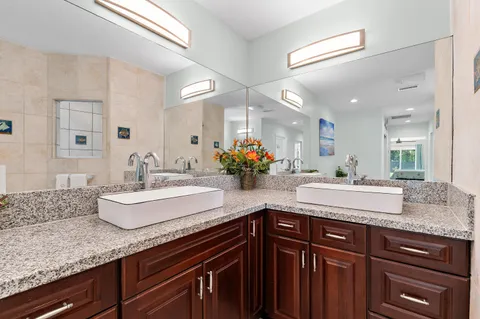 a kitchen with stainless steel appliances kitchen island granite countertop a sink and white cabinets