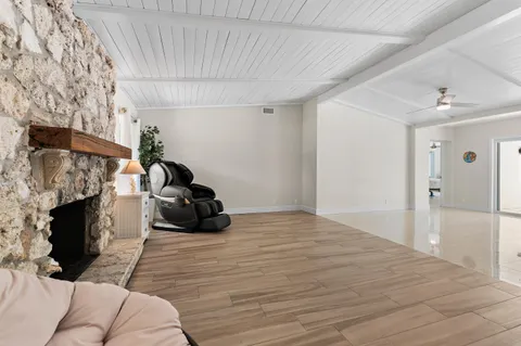 a view of a livingroom with wooden floor and a ceiling fan