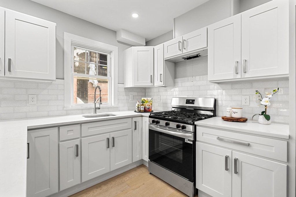 679-683 Columbia Road, Unit 1 Boston, MA 02125 - Photo 14 of 31 a kitchen with cabinets appliances a sink and a window