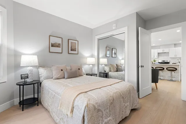 a bedroom with a bed and a view of living room